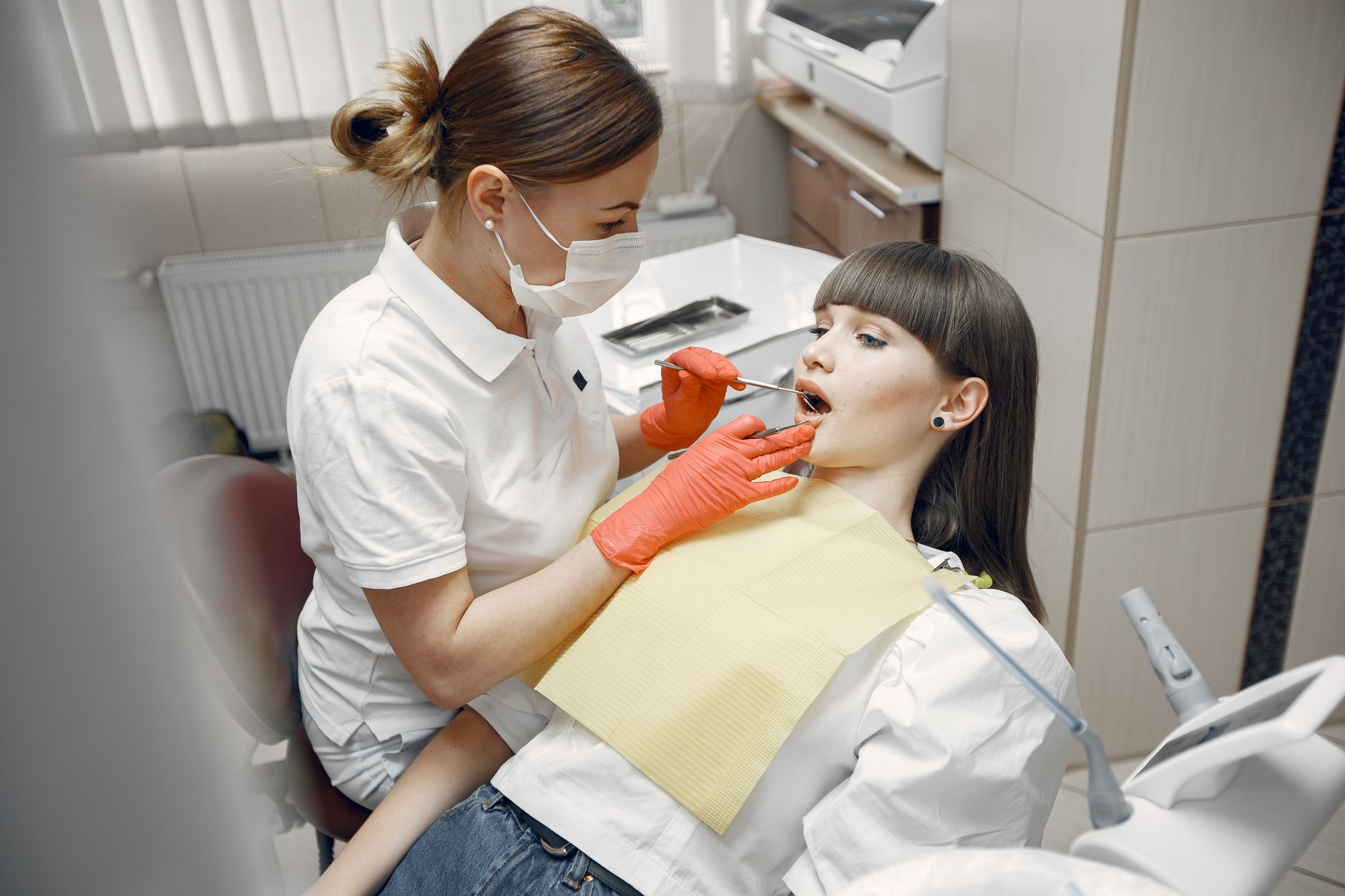 A doctor performing a medical examination to check for tonsillitis difficulty swallowing in a clinic.