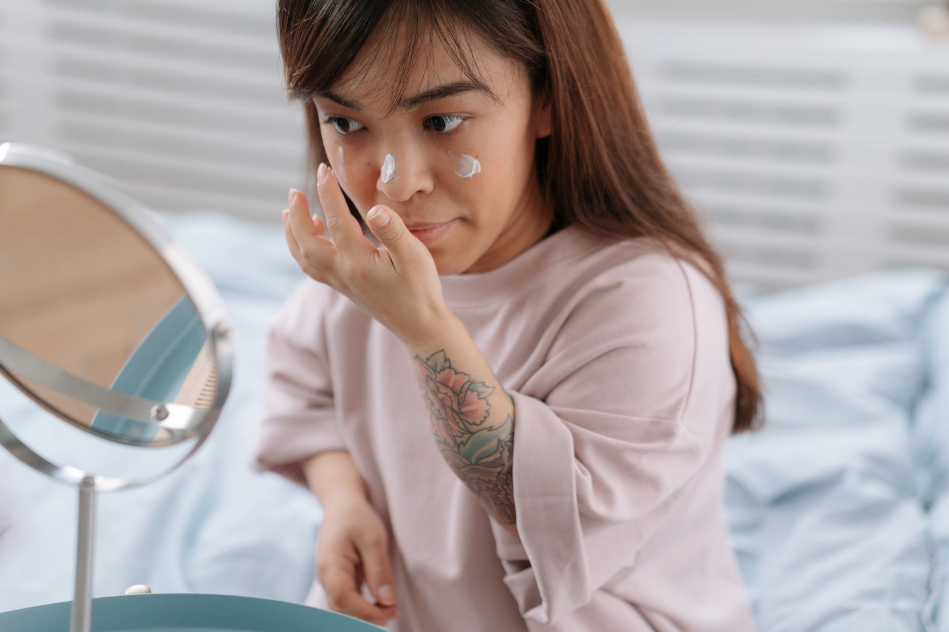 A person gently cleansing their face to help manage what causes acne.