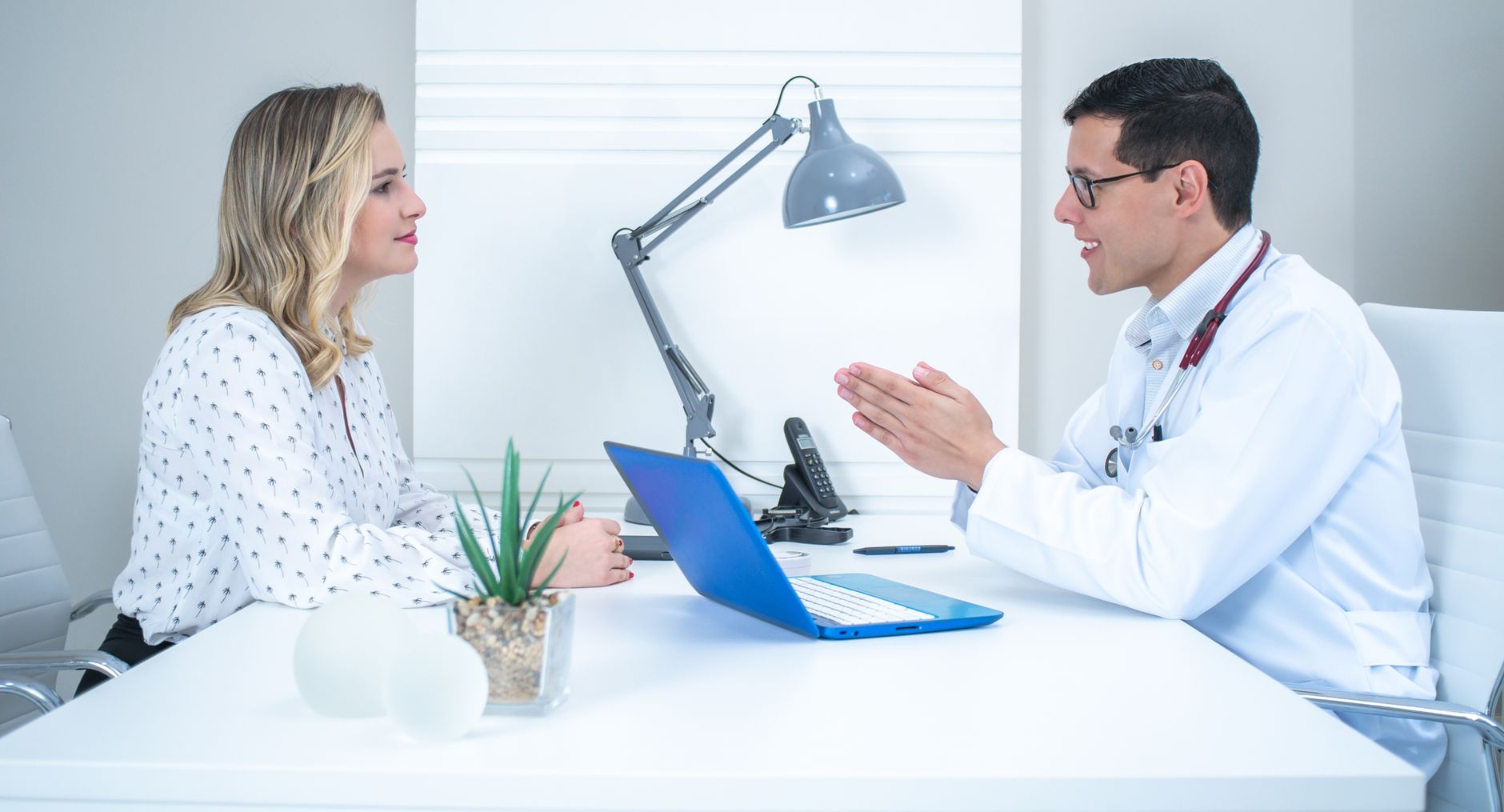 A patient discussing tonsillitis difficulty swallowing symptoms with a professional doctor during a consultation.