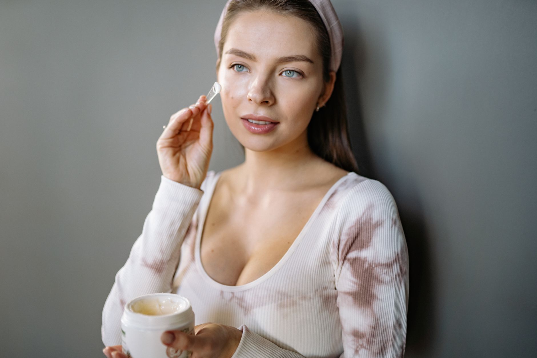 A dermatologist explaining what causes acne to a patient during a consultation.